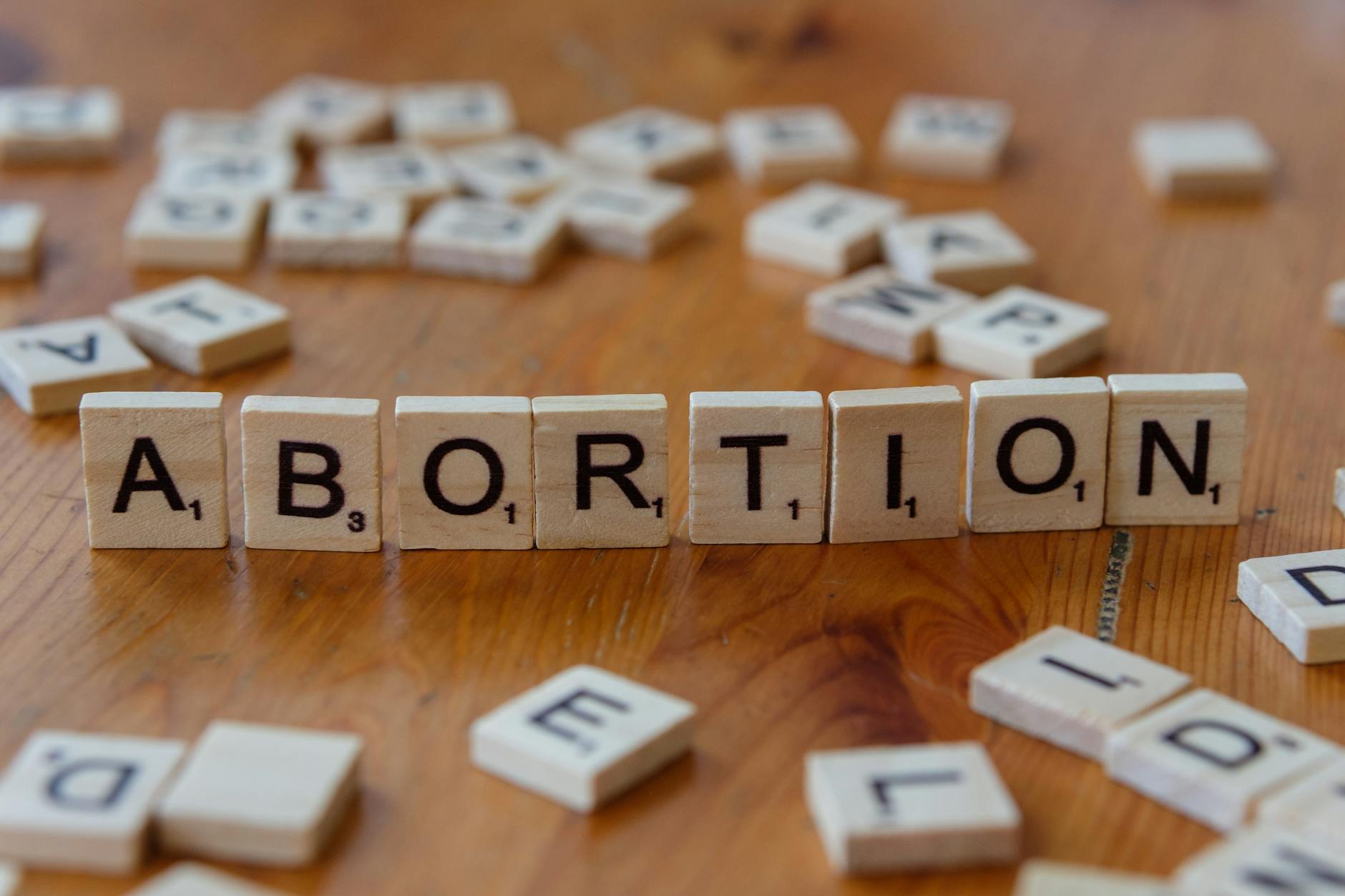 Scrabble tiles spelling 'abortion', highlighting the debate on reproductive rights.