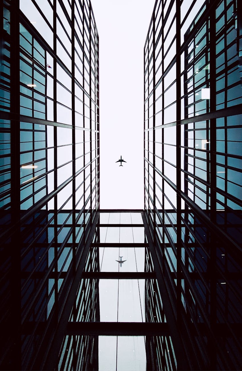 Silhouette of an airplane over towering modern glass buildings in Chile.